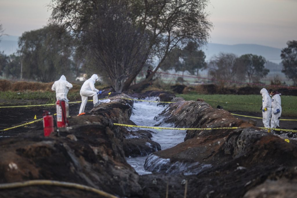 Forensic investigators examine the explosion site. Photographer: Alejandro Cegarra/Bloomberg