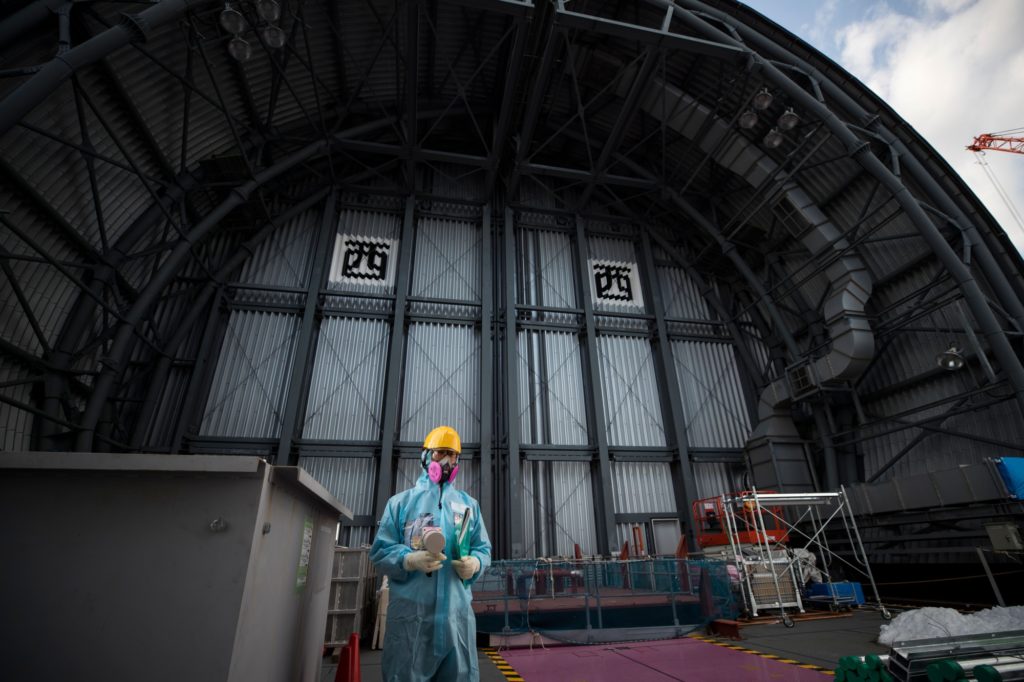 An employee of Tokyo Electric Power Company (TEPCO) holds a geiger counter to measure radiation on the top floor of the company's reactor number 3 at Fukushima Dai-ichi nuclear power plant in Okuma, Fukushima prefecture. Photographer: Behrouz Mehri/AFP/Getty Images