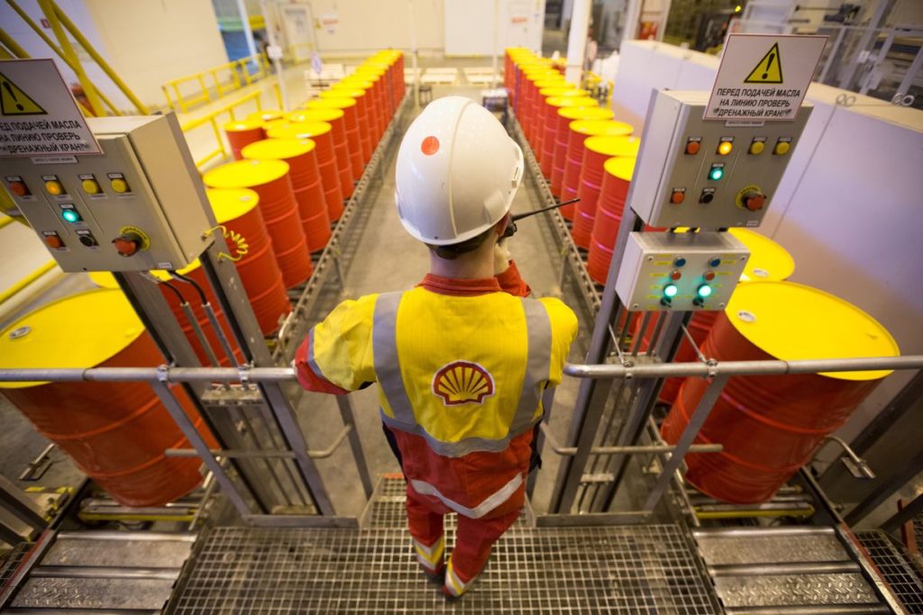 Man in overalls surrounded by yellow and orange barrels