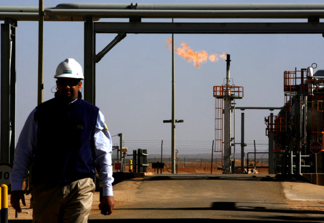 An employee walks in front of a gas flare