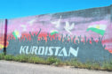 A banner saying Kurdistan with waving flags in background