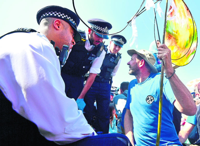 Police remove Extinction Rebellion demonstrators on Waterloo Bridge in London. PRESS ASSOCIATION Photo. Picture date: Sunday April 21, 2019. See PA story ENVIRONMENT Climate. Photo credit should read: Victoria Jones/PA Wire