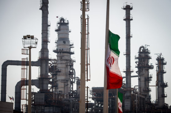 An Iranian national flag flies near gas condensate processing facilities in the new Phase 3 facility at the Persian Gulf Star Co. (PGSPC) refinery in Bandar Abbas, Iran, on Wednesday, Jan. 9. 2019. The third phase of the refinery begins operations next week and will add 12-15 million liters a day of gasoline output capacity to the plant, Deputy Oil Minister Alireza Sadeghabadi told reporters. Photographer: Ali Mohammadi/Bloomberg