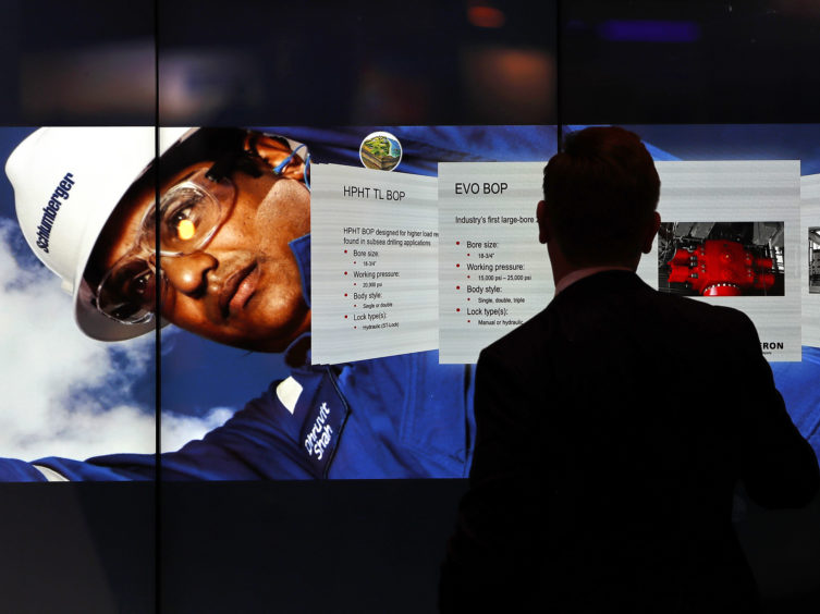 An attendee uses the Interactive Wall at the Schlumberger Ltd. booth during the 2017 Offshore Technology Conference (OTC) in Houston, Texas, U.S., on Wednesday, May 3, 2017.  Photographer: Aaron M. Sprecher/Bloomberg