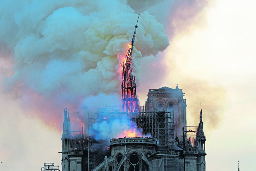 The steeple of the landmark Notre-Dame Cathedral collapses as the cathedral is engulfed in flames in central Paris on April 15, 2019.