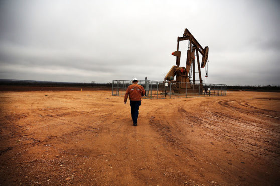 GARDEN CITY, TX - FEBRUARY 05: An oil well owned an operated by Apache Corporation in the Permian Basin are viewed on February 5, 2015 in Garden City, Texas.