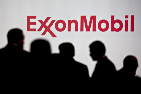 Attendees stand near Exxon Mobil Corp. signage during the World Gas Conference in Washington, D.C., U.S, on Tuesday, June 26, 2018. The 27th World Gas Conference, themed Fueling the Future, is held every three years in the country holding the Presidency of the International Gas Union (IGU). Photographer: Andrew Harrer/Bloomberg
