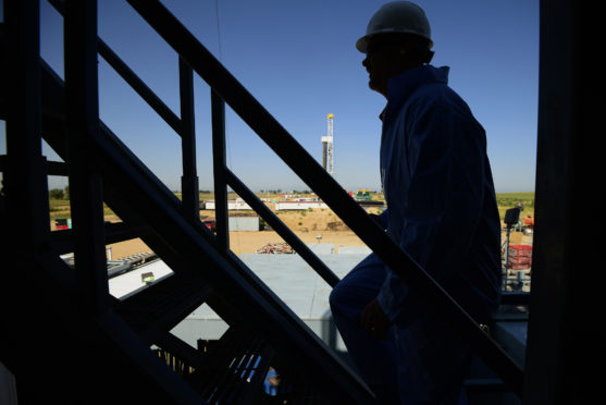 The silhouette of a contractor is seen walking up stairs at an Anadarko Petroleum Corp. oil rig site in Fort Lupton, Colorado, U.S., on Tuesday, Aug. 12, 2014. Photographer: Jamie Schwaberow/Bloomberg