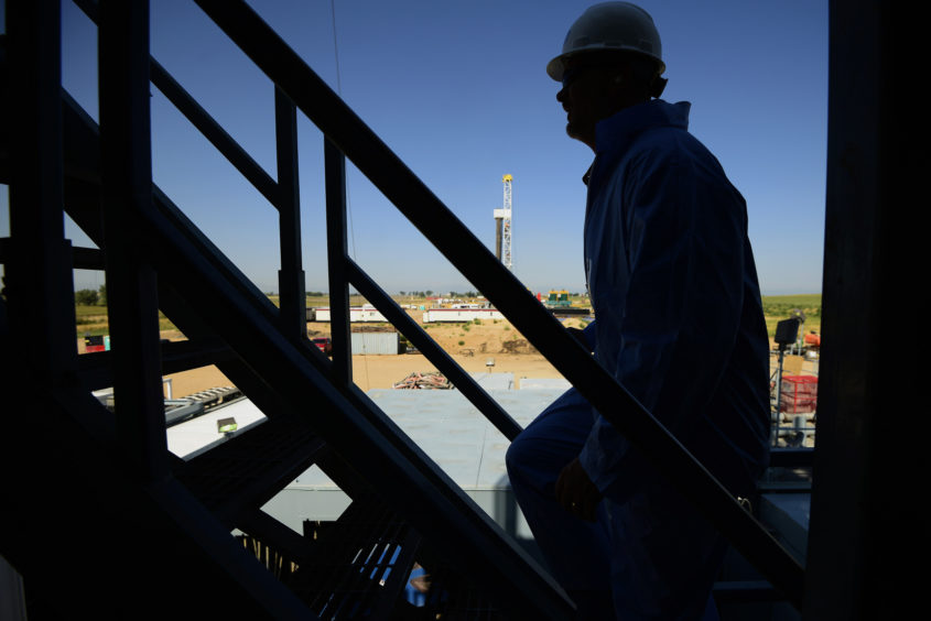 The silhouette of a contractor is seen walking up stairs at an Anadarko Petroleum Corp. oil rig site in Fort Lupton, Colorado, U.S., on Tuesday, Aug. 12, 2014.  Photographer: Jamie Schwaberow/Bloomberg