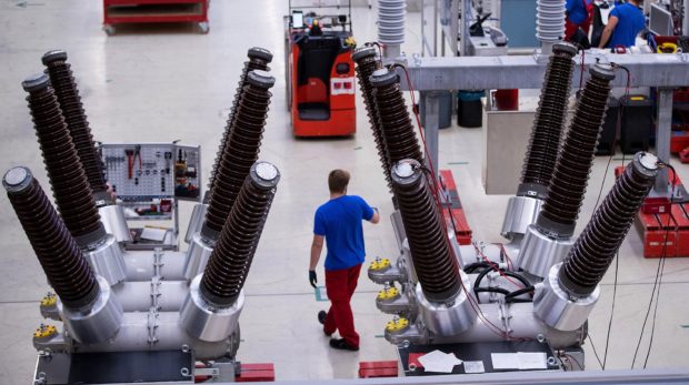 An employee stands near dead tank circuit breakers inside Siemens AG switchgear electronic power unit factory in Berlin, Germany, on Thursday, Sept. 13, 2018.