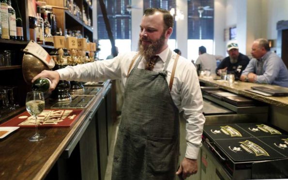 Bartender Sean Stapleton serves drinks to the regulars during happy hour at The Refuge Bar and Bistro Tuesday, Jun. 4, 2019 in The Woodlands, TX. Local area businesses are concerned about the possibility of Anadarko employees and the headquarters relocating, and The Refuge sees quite of few of those employees frequent the bar.