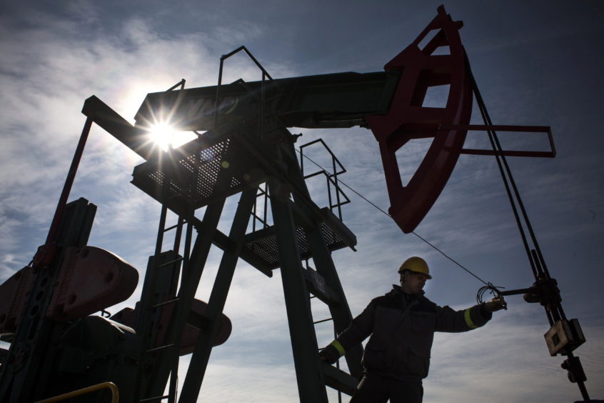 An employee works on oil pumping gear, also known as nodding donkeys or pump jacks, at an oil plant operated by MND AS in Uhrice, Czech Republic, on Monday, March 23, 2015.  Photographer: Martin Divisek/Bloomberg