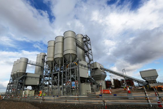 The concrete batching plant stands on the horizon as work recommences at the Hinkley Point C nuclear power station, operated by Electricite de France SA's (EDF), near Bridgwater, U.K., on Friday, Sept. 16, 2016. Photographer: Luke MacGregor/Bloomberg
