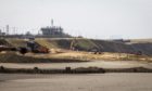 Tractors and diggers work on the beach during an operation by Royal HaskoningDHV to protect against erosion of the cliffs bordering the Bacton Gas Terminal in Bacton, U.K., Photographer: Chris Ratcliffe/Bloomberg