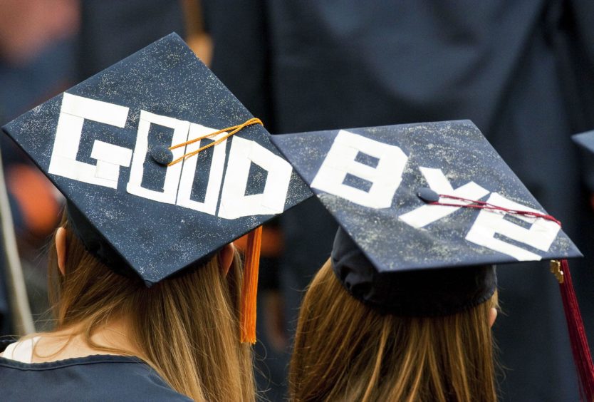 Two graduates display a farewell message on their mortarboards during Syracuse University's commencement ceremony at the Carrier Dome in Syracuse, New York, U.S., on Sunday, May 16, 2010. Students entering one of the weakest job markets in history need to have the courage to speak the truth, "even when it's unpopular," JPMorgan Chase & Co. Chief Executive Officer Jamie Dimon told graduates. Photographer: Michael Okoniewski/Bloomberg via Getty Images