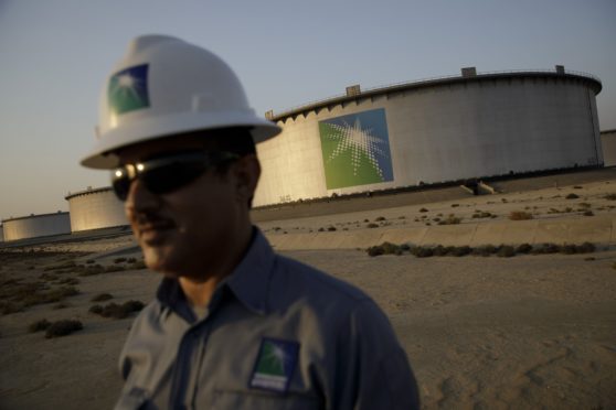 An employee visits the site of crude oil storage tanks at the Juaymah tank farm at Saudi Aramco's Ras Tanura oil refinery and oil terminal in Ras Tanura, Saudi Arabia.
