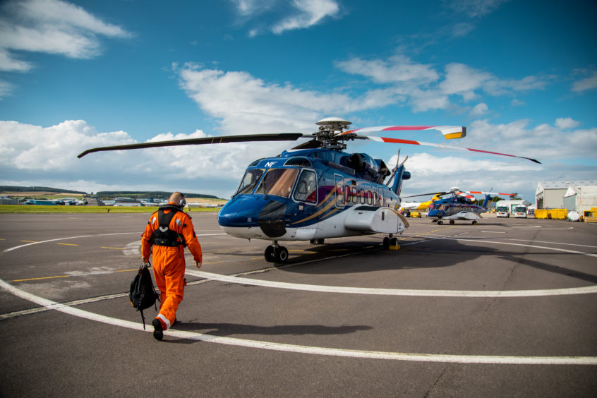 An offshore worker boarding an OHS helicopter