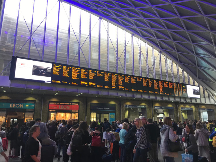 People waiting for trains at King's Cross station, London, after all services in and out of the station were suspended on Friday when a power cut caused major disruption across the country. PA