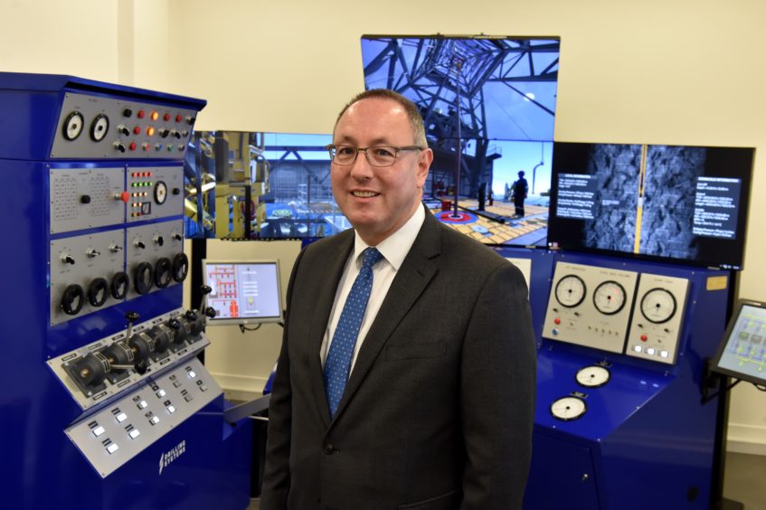 Paul de Leeuw standing in front of RGU's decommissioning simulator.