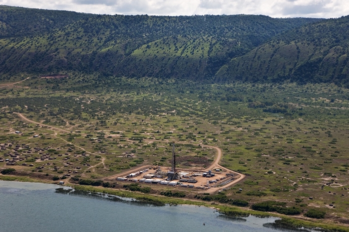 Aerial shot of a drilling rig on the side of a lake