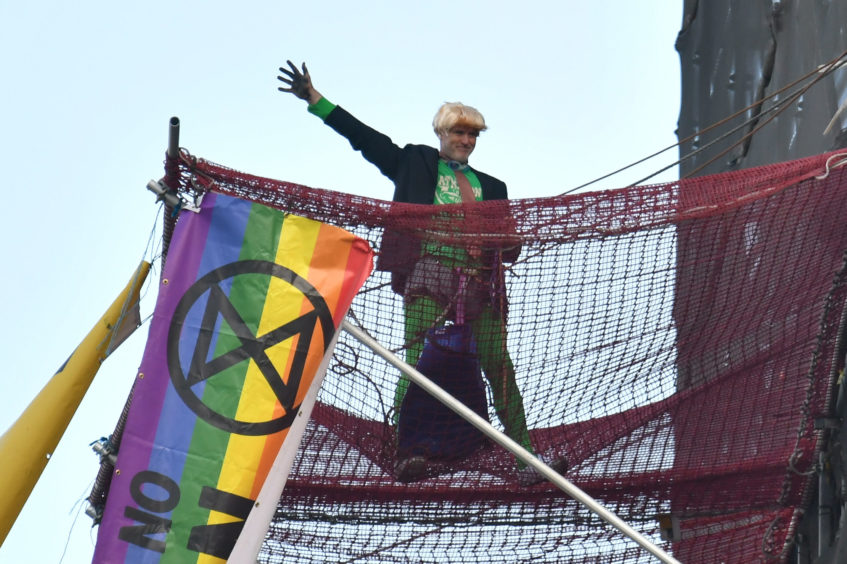 An Extinction Rebellion protester who has scaled the scaffolding surrounding Big Ben at the Houses of Parliament, Westminster, London. PA Photo. Picture date: Friday October 18, 2019. See PA story ENVIRONMENT Protests. Photo credit should read: Dominic Lipinski/PA Wire