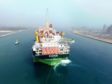 An FPSO with a green hull leaves dock