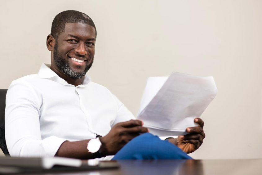 Smiling man sits at desk