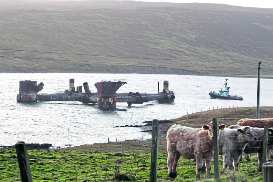 The Buchan Alpha rig breaks free in strong wind.
ALL PHOTOS: © Shetland News
THE BUCHAN Alpha oil platform which is being dismantled at Dales Voe in Lerwick broke free from the pier overnight in windy weather.
On Sunday morning the structure was sitting in the water opposite Dales Voe near to land at Gott.
Lerwick Port Authority staff arrived on scene at around 9.30am on the pilot boat Knab to assess the situation.