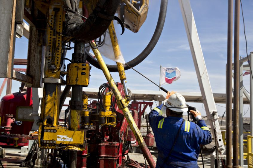 A roughneck with Nabors Industries Ltd. uses a power washer to clean the drilling floor of a Nabors rig drilling for Chevron Corp. in the Permian Basin near Midland, Texas, U.S., on Thursday, March 1, 2018. Photographer: Daniel Acker/Bloomberg