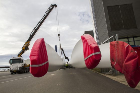 Protective covers sit on wind turbine blades as they are moved at the Vestas Wind Systems A/S blade factory in Lem, Denmark, on Wednesday, Sept. 25, 2013. Vestas Wind Systems A/S, agreed to form a venture to develop offshore wind energy with Mitsubishi Heavy Industries Ltd. Photographer: Freya Ingrid Morales/Bloomberg