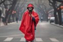 BEIJING, CHINA - JANUARY 26: A Chinese man wears a protective mask, goggles and coat as he stands in a nearly empty street during the Chinese New Year holiday on January 26, 2020 in Beijing, China. The number of cases of a deadly new coronavirus rose to over 2000 in mainland China Sunday as health officials locked down the city of Wuhan earlier in the week in an effort to contain the spread of the pneumonia-like disease.  Photo by Kevin Frayer/Getty Images)