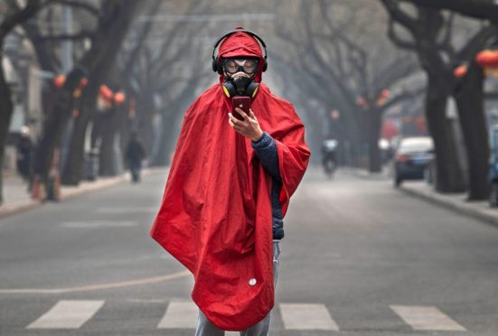 BEIJING, CHINA - JANUARY 26: A Chinese man wears a protective mask, goggles and coat as he stands in a nearly empty street during the Chinese New Year holiday on January 26, 2020 in Beijing, China. The number of cases of a deadly new coronavirus rose to over 2000 in mainland China Sunday as health officials locked down the city of Wuhan earlier in the week in an effort to contain the spread of the pneumonia-like disease. Photo by Kevin Frayer/Getty Images)