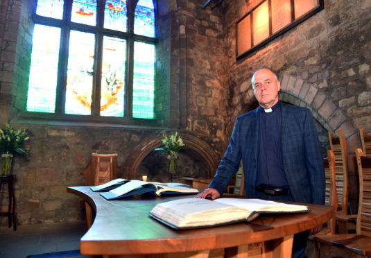 Oil and gas chaplain, Rev Gordon Craig. Normally based in Tullos, he is pictured here with the Book of Remembrance at the Kirk of St Nicholas.