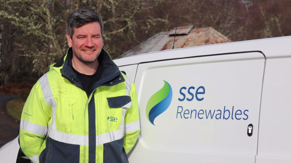 Colin Marr, SSE Renewables Wind Farm Supervisor alongside an SSE Renewables electric vehicle.
