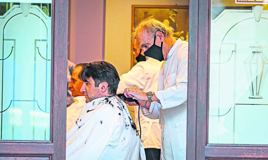 Step by step: Men in Bergamo, one of the hardest hit areas of Italy, prepare to return to work with a trip to the barber