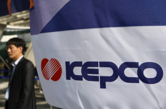 An attendee walks past Korea Electric Power Corp. (Kepco) signage displayed at the 22nd World Energy Congress (WEC) in Daegu, South Korea, on Monday, Oct. 14, 2013. Photographer: SeongJoon Cho/Bloomberg