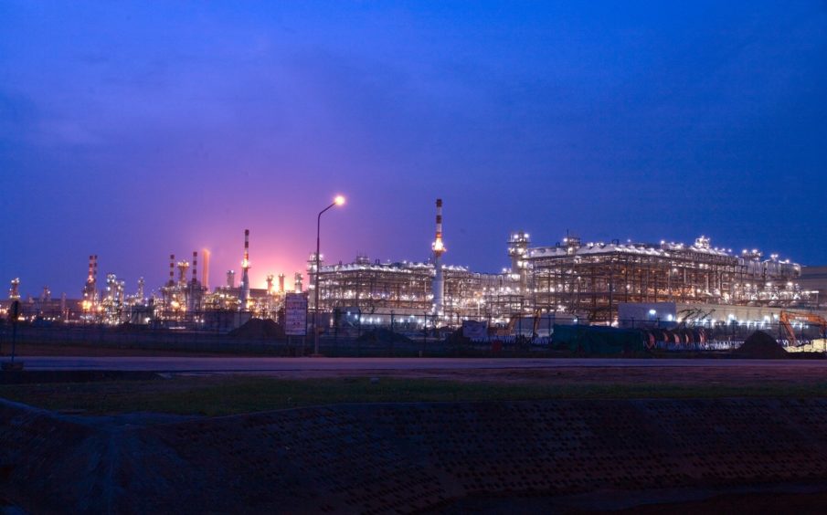 Industrial plant at night against dark blue sky