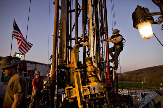 Nomac Drilling Corp. derrick man Justin Spruell, right, climbs down from an overhead platform after connecting a section of drill pipe on a Chesapeake Energy Corp. natural gas drill site in Bradford County, Pennsylvania, U.S., on Tuesday, April 6, 2010. Photographer: Daniel Acker/Bloomberg