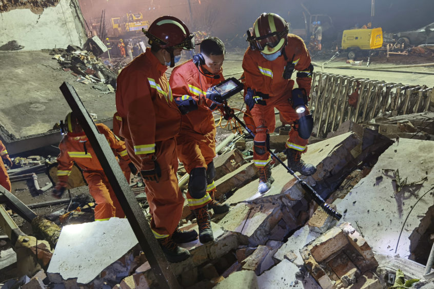 Firefighters look for residents trapped in collapsed buildings in the aftermath of a tanker truck explosion near a highway in Wenling in eastern China's Zhejiang province Saturday, June 13, 2020. More than a dozen were killed and others injured after the tanker truck veered off the Shenyang-Haikou Expressway after the explosion. (Chinatopix via AP)
