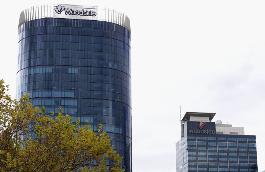 The Woodside Petroleum Ltd. logo is displayed atop the company's new headquarters, left, and Woodside Plaza building in Perth, Australia. Photographer: Sergio Dionisio/Bloomberg