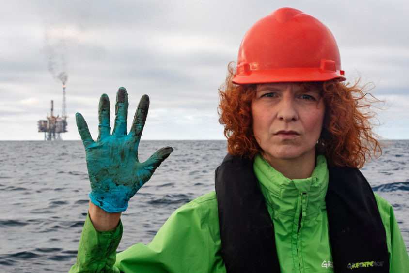 Greenpeace Germany Oceans campaigner Sandra Schoettner shows her gloves with the Andrew platform in the background. 
© Marten van Dijl / Greenpeace