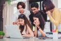 Group of five young euphoric students watching exam results in a laptop in a table of an university campus bar.; Shutterstock ID 720895372; Purchase Order: -