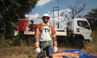 Man in hard hat stands in front of white lorry