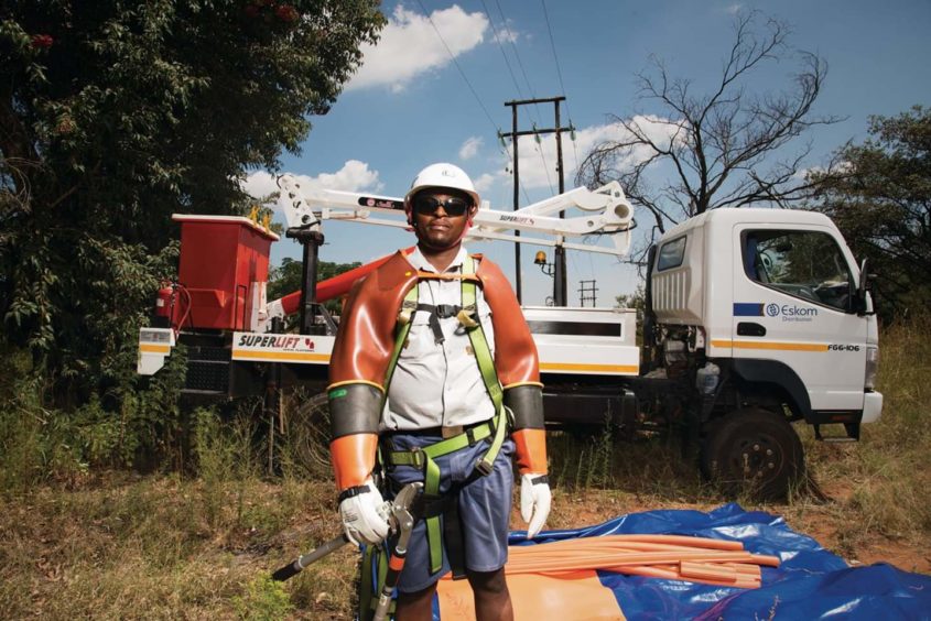 Man in hard hat stands in front of white lorry