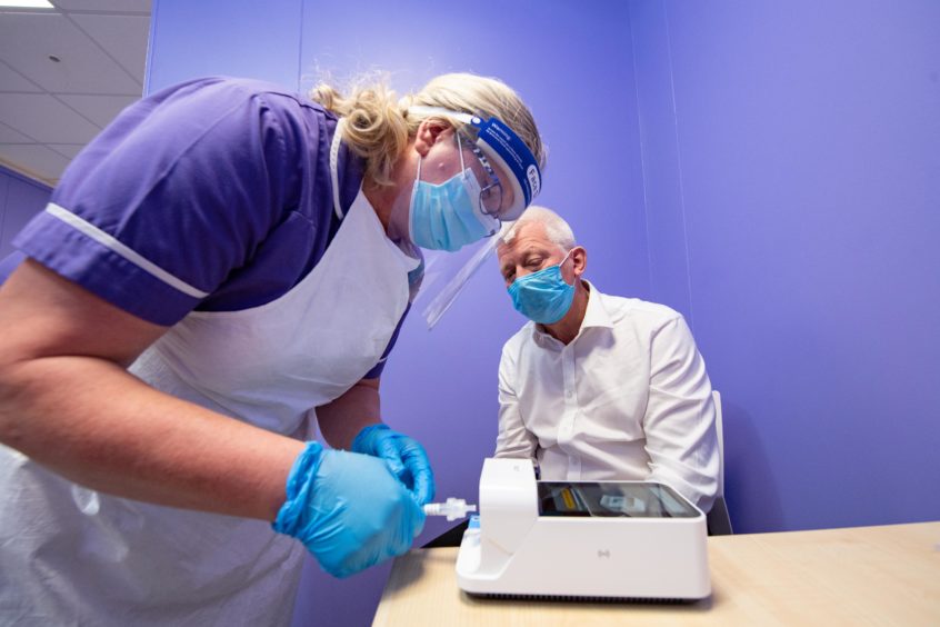 hi-tech: Group clinical director Ken Park looks on as a Covid-19 test is carried out. The firm aims to help relieve pressure on the NHS