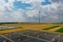 Solar panels sit on top of a warehouse near the hydrogen electrolysis plant at Energiepark Mainz, operated by Linde AG, left, in view of wind turbines in Mainz, Germany, on Friday, July 17, 2020.