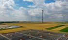 Solar panels sit on top of a warehouse near the hydrogen electrolysis plant at Energiepark Mainz, operated by Linde AG, left, in view of wind turbines in Mainz, Germany, on Friday, July 17, 2020.