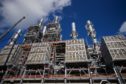 Industrial pipes and chimneys under a blue sky