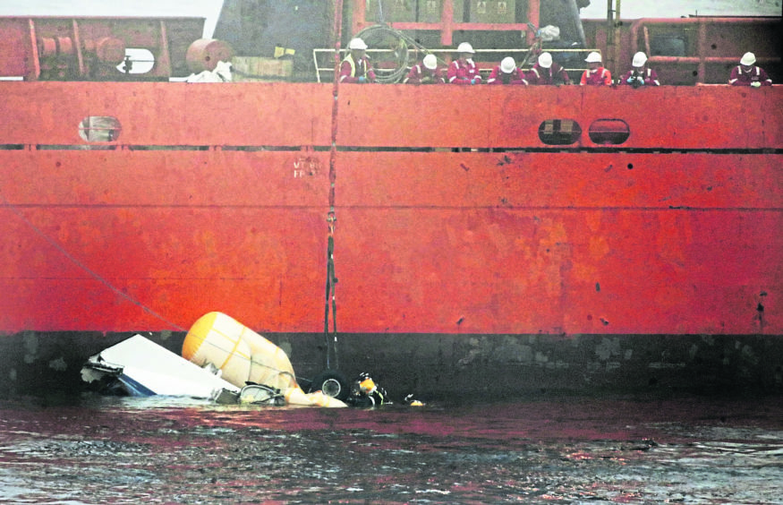 grim TASK: A diver works on the wreckage of the Super Puma helicopter which went down in foggy conditions off Shetland with the loss of four lives on August 23 2013