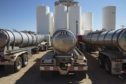 Tanker trucks sit in front of storage silos in Sunray, Texas, U.S., on Saturday, Sept. 26, 2020. After all the trauma the U.S. oil industry has been through this year -- from production cuts to mass layoffs and a string of bankruptcies -- many producers say theyre still prioritizing output over reducing debt. Photographer: Angus Mordant/Bloomberg